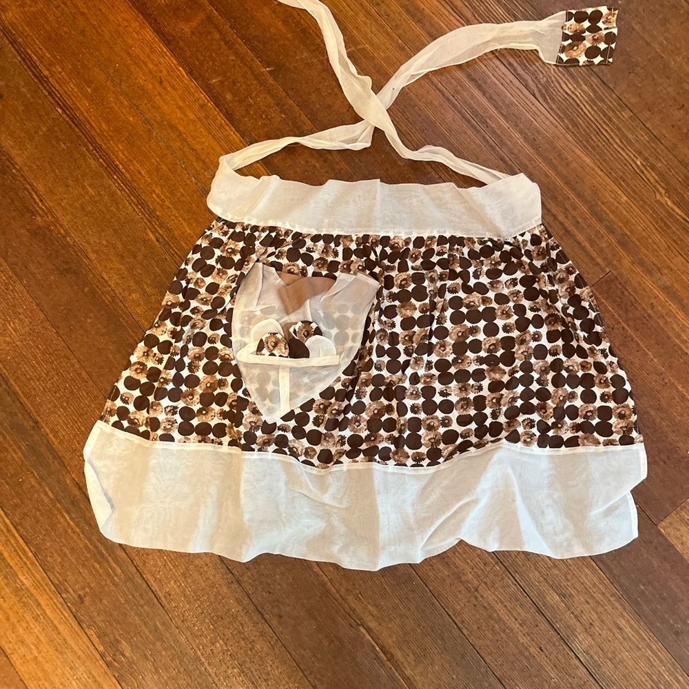 Vintage apron. Brown and white with a pocket and long ties for making a bow.